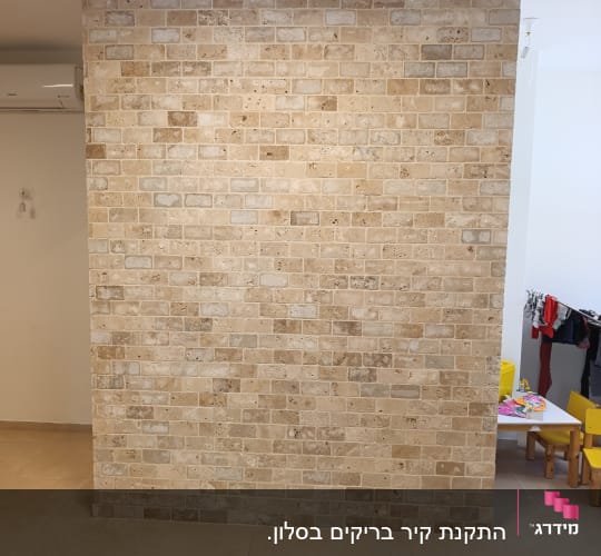 קיר לבנים בחדר עם רהיטים קטנים
